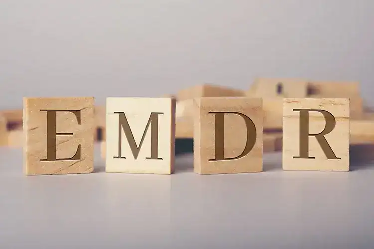 Wooden blocks spelling "EMDR" for therapy and mental health support.