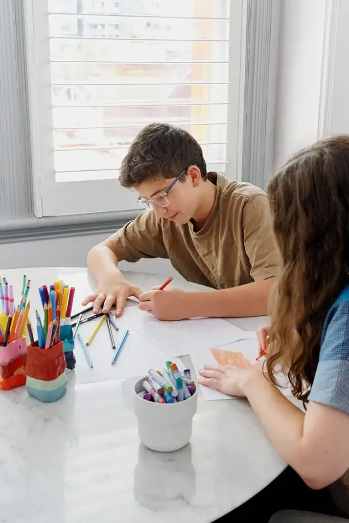 Child engaging in sensory profiling assessment with therapist at a bright table.
