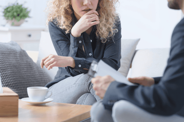 Woman in a therapy session discussing learning difficulties with a psychologist.